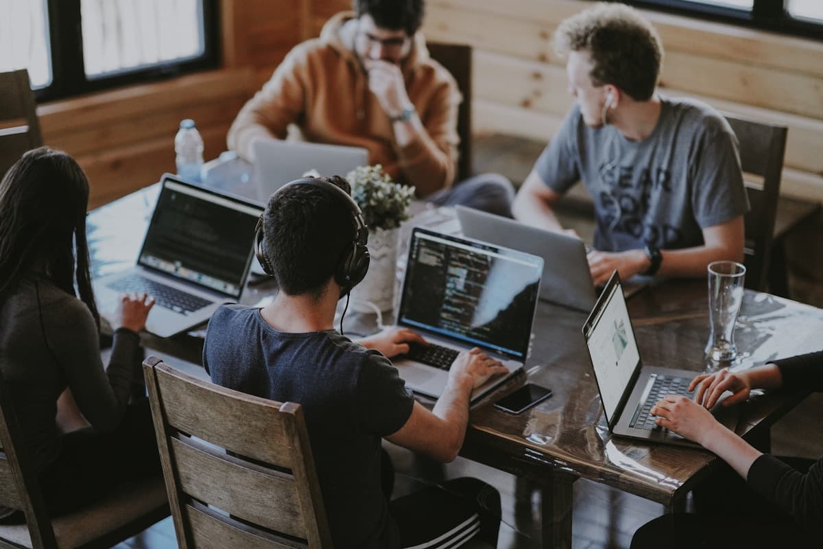 Team collaborating at laptops in a modern workspace